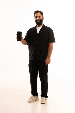 عرض شاشة سوداء فارغة، استخدام التقنيات والتكنولوجيا الحديثة والمتطورة، إيماءات السعادة بسماع أخبار جيدة، بورتريه لرجل عربي خليجي عماني يرتدي الزى الكاجوال  يمسك الهاتف المحمول بيده ، الجسم بالطول الكامل، خلفية بيضاء