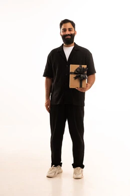 التعبير عن الحب والتقدير والاحترام، مفهوم الشكر والامتنان، تقديم الهدايا بالاعياد والمناسبات الخاصة، بورتريه لرجل عربي خليجي عماني يرتدي الزي الكاجوال يحمل صندوق هدية ينظر بايماءات السعادة، الجسم بالطول الكامل، خلفية بيضاء