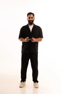 بورتريه لرجل عربي خليجي عماني يرتدي الزي الكاجوال يحمل بيده عصا التحكم، إيماءات الاستمتاع والاندماج، استخدام الأجهزة التكنولوجية والتقنيات الحديثة، قضاء أوقات ممتعة في ألعاب الفيديو الترفيهيه،خلفية بيضاء