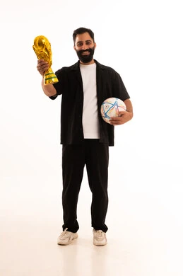 تشجيع الأنديه والمنتخبات، ايماءات السعادة و السرور، الشغف في مباريات كرة القدم، بورتريه لرجل عربي عماني يرتدي الزي الكاجوال يحمل بيدية الكرة وكأس الفوز، خلفية بيضاء