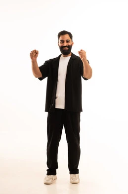 اللياقة البدنية والجسم الصحي المتين، التمتع بالبنية الجسدية القوية، بورتريه مقرب لرجل عربي خليجي عماني يرتدي الزي الكاجوال يقوم بعرض عضلات يديه ينظر الى الكاميرا بإيماءات القوة، صورة الجسم بالطول الكامل، خلفية بيضاء