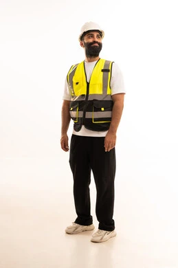 العمل في القطاع الهندسي، مفهوم الهندسة والانشاءات المعمارية، بورتريه لمهندس عربي خليجي عماني يرتدي الزي الكاجوال والخوذة وسترة الحماية ينظر بتعابير السرور، مهنة ووظيفة للشباب في سلطنة عمان، الجسم بالطول الكامل، خلفية بيضاء