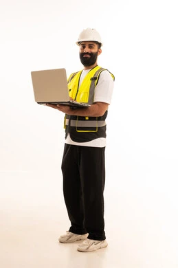 دمج التقنيات الحديثة ،إدارة المشاريع بحرفية باستخدام الحاسوب المحمول ، العمل في القطاع الهندسي، مفهوم الهندسة والانشاءات المعماريه، بورتريه  لمهندس عربي خليجي عماني يرتدي الزي الكاجوال والخوذة وسترة الحماية يمسك بيده اللابتوب، خلفية بيضاء