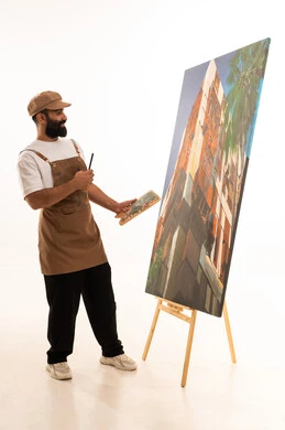 ورشة عمل وفنون, استخدام ريشة التلوين، أنشطة ترفيهية فنية ممتعة، بورتريه لرسام عربي خليجي عماني يرتدي الزي الكاجوال وقبعة يحمل بيديه الالوان المائية, خلفية بيضاء