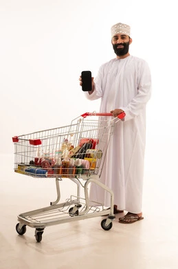تصفح مواقع التواصل الاجتماعي ، استخدام التكنولوجيا والتقنيات الحديثة، شراء المستلزمات والحاجيات الضرورية، الاستمتاع بالتسوق في المولات والمراكز التجارية، الاستفادة من الخصومات والتنزيلات على المنتجات، بورتريه لرجل عربي خليجي عماني يرتدي الدشداشة والكمة يقف و عربة المشتريات أمامه يمسك الجوال بيده ، الجسم بالطول الكامل، خلفية بيضاء تصفح مواقع التواصل الاجتماعي ، استخدام التكنولوجيا والتقنيات الحديثة، شراء المستلزمات والحاجيات الضرورية، الاستمتاع بالتسوق في المولات والمراكز التجارية، الاستفادة من الخصومات والتنزيلات على المنتجات، بورتريه لرجل عربي خليجي عماني يرتدي الدشداشة والكمة يقف و عربة المشتريات أمامه يمسك الجوال بيده ، الجسم بالطول الكامل، خلفية بيضاء