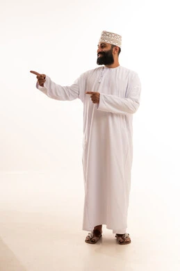 حركات تدل على هذا المكان (هنا), الدلالة على موقع معين, تحديد مكان عنصر محدد, بورتريه لشاب عربي خليجي عماني يرتدي الدشداشة و الكمة يشير بإصبع السبابة إلى شيء ما, الجسم بالطول الكامل, خلفية بيضاء حركات تدل على هذا المكان (هنا), الدلالة على موقع معين, تحديد مكان عنصر محدد, بورتريه لشاب عربي خليجي عماني يرتدي الدشداشة و الكمة يشير بإصبع السبابة إلى شيء ما, الجسم بالطول الكامل, خلفية بيضاء