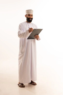 Recording notes and important information, a portrait of an Arab Gulf Omani man wearing a dishdasha and kumma holding a black notepad and a pen in his hands, writing something with gestures of focus and contemplation, tools for recording daily tasks, full-body, white background.