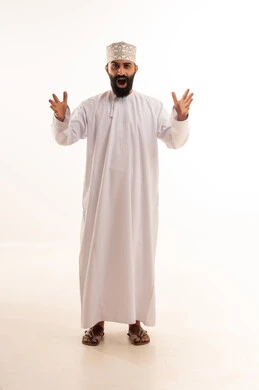 الشعور بالدهشة والصدمة والذهول, التفاجؤ من شيء ما،بورتريه لشاب عربي خليجي عماني يرتدي الدشداشة والكمة ينظر الى الكاميرا يرفع يديه بإيماءات الغضب والانفعال, صورة الجسم بالطول الكامل, خلفية بيضاء