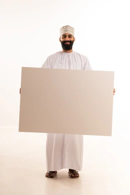 Gestures of happiness and joy, advertisements and marketing offers, use of illustrative boards and educational tools, a portrait of a smiling Arab Gulf Omani man wearing a dishdasha and a kumma holding a large white board (empty mock-up) in his hand, full body length, white background.