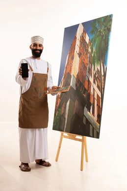 أنشطة ترفيهية فنية ممتعة، استخدام ريشة التلوين،بورتريه لرسام عربي خليجي عماني يرتدي الدشداشة والكمة وقبعة يحمل بيديه الالوان المائية, ورشة عمل وفنون, خلفية بيضاء