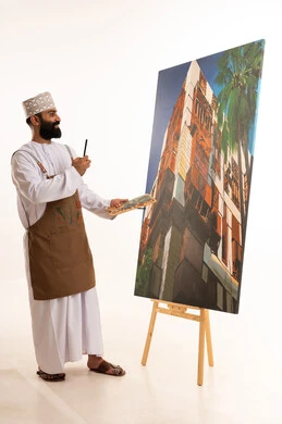 Using a coloring brush, fun artistic recreational activities, a portrait of an Arab Gulf Omani painter wearing a dishdasha and kumma and a hat holding watercolor paints in his hands, workshop and arts, white background.