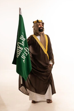 يوم بدينا 1727م ، ذكرى تأسيس الدولة السعودية الأولى في 22 فبراير،تذكار اليوم الوطني السعودي 23 سبتمبر، بورتريه لرجل عربي سعودي خليجي يرتدي البشت والغتره وعقال يوم التأسيس يرفع علم السعوديه, يوم العلم ١١ مارس ، خلفية بيضاء