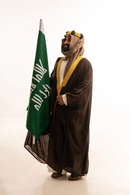 A portrait of a Saudi Arabian Gulf man wearing a bisht, ghutrah, and agal on Founding Day, raising the Saudi flag. Flag Day is on March 11, the anniversary of the establishment of the first Saudi state on February 22, the day we began in 1727 AD, a reminder of Saudi National Day on September 23, with a white background. A portrait of a Saudi Arabian Gulf man wearing a bisht, ghutrah, and agal on Founding Day, raising the Saudi flag. Flag Day is on March 11, the anniversary of the establishment of the first Saudi state on February 22, the day we began in 1727 AD, a reminder of Saudi National Day on September 23, with a white background.