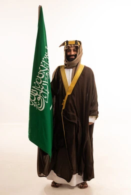 ذكرى تأسيس الدولة السعودية الأولى في 22 فبراير، يوم بدينا 1727م ، تذكار اليوم الوطني السعودي 23 سبتمبر، بورتريه لرجل عربي سعودي خليجي يرتدي البشت والغتره وعقال يوم التأسيس يرفع علم السعوديه, يوم العلم ١١ مارس ، خلفية بيضاء