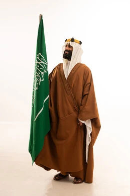 A portrait of an Arab Saudi Gulf man wearing a bisht, ghutrah, and agal on Founding Day, raising the Saudi flag. Flag Day is on March 11, the anniversary of the establishment of the first Saudi state on February 22, the day we began in 1727, a reminder of Saudi National Day on September 23, with a white background.