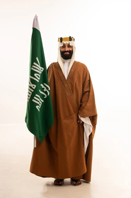 ذكرى تأسيس الدولة السعودية الأولى في 22 فبراير، يوم بدينا 1727م ، تذكار اليوم الوطني السعودي 23 سبتمبر، بورتريه لرجل عربي سعودي خليجي يرتدي البشت والغتره وعقال يوم التأسيس يرفع علم السعوديه, يوم العلم ١١ مارس ، خلفية بيضاء