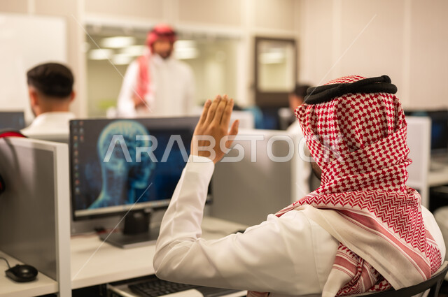 المشاركة الفعالة للطلاب,  معلم عربى خليجى سعودى يرتدى الثوب التقليدى والشماغ  يقوم بالشرح و التدريب على اجهزة الحاسوب, الدراسة والتعلم فى المملكة العربية السعودية
