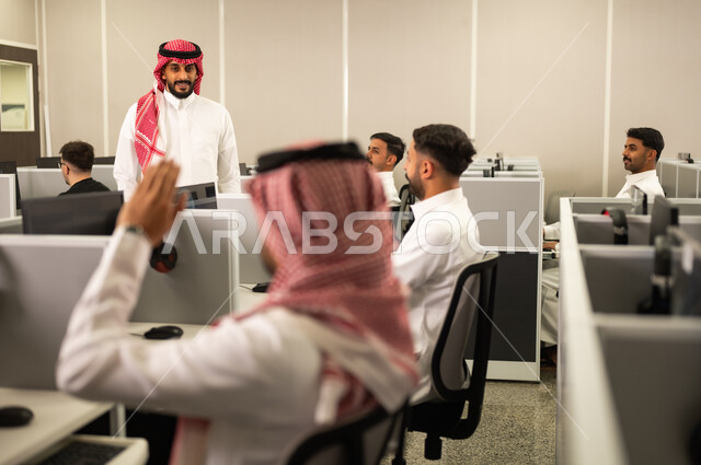 الإستماع الى المحاضره، رفع اليدين داخل الفصل، أستاذ جامعى عربي خليجي سعودي يرتدي الثوب التقليدي والشماغ يقوم بالتدريب على اجهزة الحاسوب, جامعات أكاديميه فى المملكة العربية السعودية ,مفهوم تدريب وتطوير الموظفين