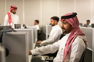 دمج التكنولوجيا والتقنيات الحديثة بالحياة العملية, طالب عربى خليجى سعودى يرتدى الثوب التقليدى فى مختبرالحاسوب، التعليم فى المملكة العربية السعودية, مجموعة من الموظفين العرب الخليجيين السعوديين يعملون فى مقر الشركة