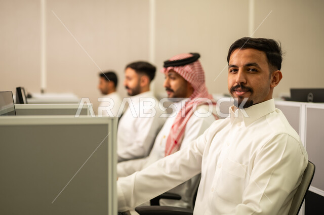 تعابير الثقة بالنفس، ارتداء سماعة الرأس والعمل على جهاز الحاسوب في خدمة العملاء في مقر الشركة, التعليم فى المملكة العربية السعودية,  طلاب عرب يجلسون أمام أجهزة الكومبيوتر في المختبر