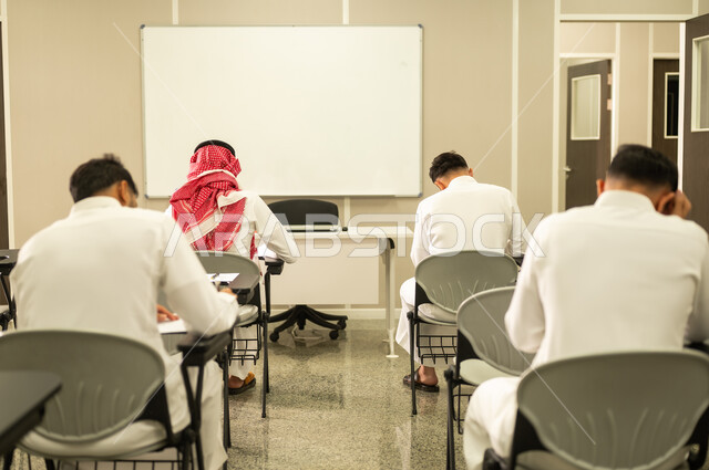 التمعن والتفكير بالإجابات المنطقية,  مجموعة من الطلاب العرب الخليجيون السعوديون يقومون بحل أسئلة الاختبار,الحفاظ على الهدوء في قاعة الصف, التعليم بالمملكة العربية السعودية