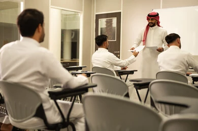 Students striving for excellence; a Saudi Arabian teacher distributing exam papers; a student answering questions; monitoring students during exams; educational goals; end of the academic year; education in the Kingdom of Saudi Arabia