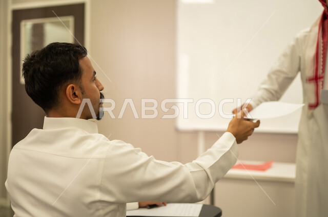 الامتحانات النهائية، اجتهاد الطلاب لتحقيق التفوق، معلم عربي خليجي سعودي يقوم بتوزيع أوراق الامتحانات، طالب يجيب على الأسئلة، متابعة الطلاب أثناء أداء الاختبارات، أهداف التربية والتعليم، نهاية العام الدراسي، التعليم بالمملكة العربية السعودية