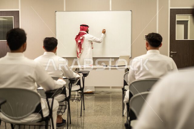 المشاركة الفعالة للطلاب, معلم عربي خليجي سعودي يقوم بشرح الدرس، مجموعة من الطلاب يتفاعلون في الحصة الدراسية من خلال الاستماع الجيد للمدرس،أهداف التربية والتعليم، التفاعل داخل الفصل الدراسي، التعليم في السعودية