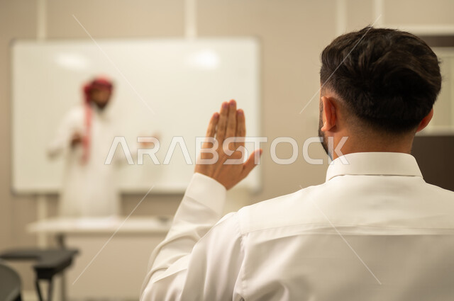 مشاركة الطالب بواسطة رفع الايدي, التفاعل داخل الصف, استخدام اللوحة المدرسية البيضاء،معلم عربي خليجي سعودي يقوم بشرح الدرس, أهداف التربية والتعليم، التعليم في السعودية