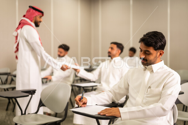 End of term exams, A Saudi Arabian student wearing traditional attire takes the exam questions Education in Saudi Arabia, goals of education