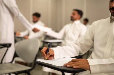 جودة التعليم في السعودية, الاستعداد لحل أسئلة الامتحان, المقررات والمناهج التعليمية الحديثة والمطورة في المملكة العربية السعودية, اختبارات نهاية الفصل الدراسي, طالب عربى خليجى سعودى يرتدى الثوب التقليدى يقوم بحل اسئلة الاختبار, التعليم في المملكة العربية السعودية, اهداف التربية و التعليم