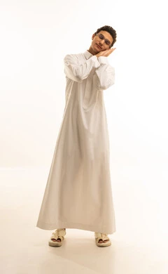 Fatigue, exhaustion, and drowsiness, staying up late at night, a portrait of a Gulf Arab Saudi man wearing traditional attire and glasses, resting his hands under his head with gestures of lethargy and laziness, white background.