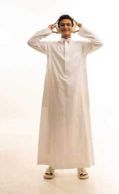 Interacting with musical melodies using headphones, gestures of immersion with the song, a portrait of an Arab Gulf Saudi man wearing traditional attire and glasses, listening to music through headphones with expressions of listening and enjoyment, artistic singing talent, full-body, white background.