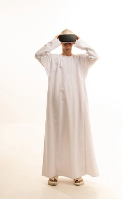 محاكاة العالم الخيالي, ارتداء نظارات الواقع الافتراضي, استخدام الأجهزة التقنية الحديثة,بورتريه لرجل عربي خليجي عماني يرتدي الدشداشة والكمة يضع نظارة الفي ار ثلاثية الأبعاد، قضاء وقت ممتع باللعب في العاب الفيديو ، خلفية بيضاء