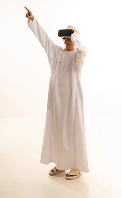 ارتداء نظارات الواقع الافتراضي,محاكاة العالم الخيالي, استخدام الأجهزة التقنية الحديثة,بورتريه لرجل عربي خليجي عماني يرتدي الدشداشة والكمة يضع نظارة الفي ار ثلاثية الأبعاد، قضاء وقت ممتع باللعب في العاب الفيديو ، خلفية بيضاء