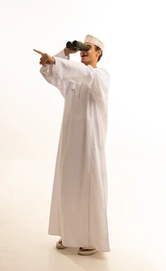 Seeing distant things through a telescope with gestures of amazement and joy, future planning for goals and ambitions, a portrait of an Arab Gulf Omani man wearing a dishdasha and kumma looking through a binocular, love for exploration and adventure, white background.