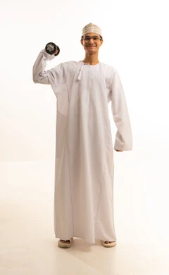 بناء عضلات الجسم وتقويتها، رفع الأوزان الحديدية الثقيلة، نشاط بدني للمحافظة على اللياقة الجسدية، بورتريه لرجل عربي خليجي عماني يرتدي الدشداشة والكمة ونظارات طبية يحمل الأثقال بيده ، خلفية بيضاء