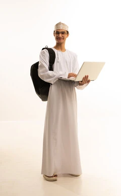 The concept of distance education, educational materials and curricula in the Kingdom, following lectures through advanced educational platforms, a portrait of an Arab Gulf Omani man wearing a dishdasha and kumma, with glasses, carrying a backpack and holding a laptop, full-body image, white background.