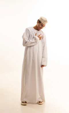 Fatigue, exhaustion, and psychological pressures, heart disorders and diseases, feeling an increased heart rate, the sensation of angina, a portrait of an Arab Gulf Omani man wearing a dishdasha and kumma and medical glasses, placing his hand on his chest with gestures of pain, full-body, white background.