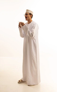 Influenza and pneumonia, feeling sick and coughing, a portrait of an Arab Gulf Omani man wearing a dishdasha and kumma and medical glasses holding a handkerchief suffering from a cough, infected with the coronavirus, feeling tired and exhausted, full-body, white background.