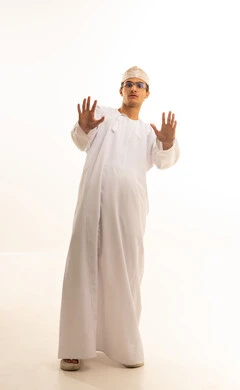 طلب التوقف والإمتناع عن فعل شيء ما، بورتريه لرجل عربي خليجي عماني يرتدي الدشداشة والكمة يرفع يده لأعلى بإشارة توقف، إيماءات الخوف والقلق والانزعاج من أمر ما، عدم القبول ورفض الأذى، خلفية بيضاء