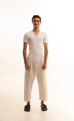 مفهوم الرجولة والأناقة، الاهتمام بالمظهر الخارجي، بورتريه لرجل عربي خليجي سعودي يرتدي السروال والفانيلة البيضاء  ينظر الى شئ ما بايماءات السعادة ، الجسم بالطول الكامل، خلفية بيضاء