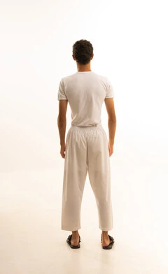 بورتريه من الخلف لرجل عربي خليجي سعودي يرتدي السروال والفانيلة البيضاء  ينظر الى شئ ما بايماءات السعادة ، مفهوم الرجولة والأناقة، الاهتمام بالمظهر الخارجي، الجسم بالطول الكامل، خلفية بيضاء