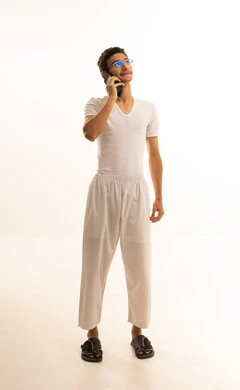 اجراء مكالمة هاتفية ، ايماءات الفرح والسعادة، بورتريه لرجل عربي خليجي سعودي يرتدي السروال والفانيله البيضاء يمسك بيده الهاتف المحمول، دمج التكنولوجيا المتطورة الى الحياه اليومية، استخدام جهاز تقني حديث ومتطور، خلفية بيضاء