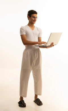 إنجاز المهام المطلوبة عبر اللابتوب،  ادارة الأعمال عن بعد، استخدام الأجهزة الحديثة والمتطورة، بورتريه لرجل عربي خليجي سعودي يرتدي السروال والفانيله البيضاء  يقوم باستخدام الحاسوب المحمول، دمج التكنولوجيا بالعمل، مهن ووظائف سعودية ، خلفية بيضاء