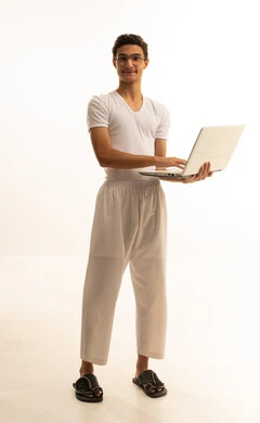 استخدام الأجهزة الحديثة والمتطورة، ادارة الأعمال عن بعد،بورتريه لرجل عربي خليجي سعودي يرتدي السروال والفانيله البيضاء  يقوم باستخدام الحاسوب المحمول، دمج التكنولوجيا بالعمل، إنجاز المهام المطلوبة عبر اللابتوب، مهن ووظائف سعودية ، خلفية بيضاء