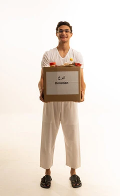 توفير الطعام للمحتاجين، التبرعات وعمل الخير ، بورتريه لرجل عربي خليجي سعودي يرتدي السروال والفانيله البيضاء يحمل صنوق تبرع ملئ بالمواد الغذائية ،مبادرات انسانية خيرية، جمعيات اسلامية في السعودية، خلفية بيضاء