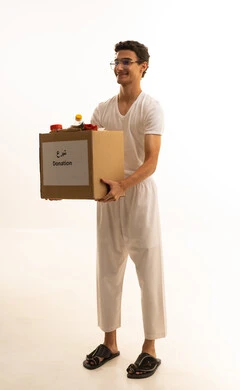 التبرعات وعمل الخير ، توفير الطعام للمحتاجين، بورتريه لرجل عربي خليجي سعودي يرتدي السروال والفانيله البيضاء يحمل صنوق تبرع ملئ بالمواد الغذائية ،مبادرات انسانية خيرية، جمعيات اسلامية في السعودية، خلفية بيضاء