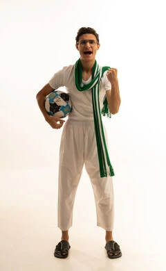 Gestures of passion and encouragement for the team, watching and following a football match, a portrait of an Arab Gulf Saudi man wearing white pants and a t-shirt and a scarf, raising his hand with expressions of enthusiasm and interaction with the national team, different sports clubs, white background.