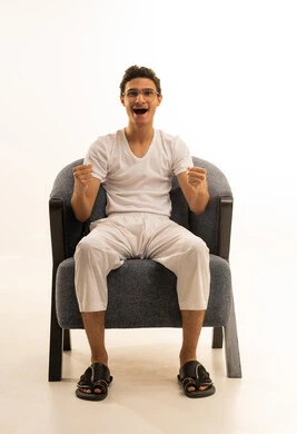 إيماءات الشغف والتشجيع للفريق، مشاهدة ومتابعة مباراة كرة القدم، بورتريه لرجل عربي خليجي سعودي يرتدي السروال والفانيله البيضاء والوشاح يرفع يده بتعابير الحماس والتفاعل مع المنتخب، أنديه رياضية مختلفة، خلفية بيضاء .